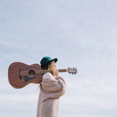 拿着棕色原声吉他的女人